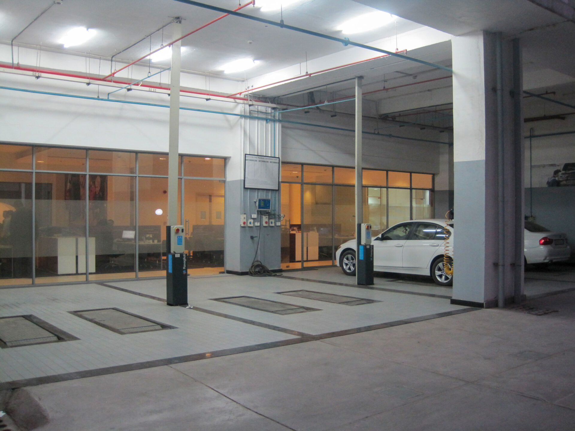 A pair of Ravaglioli scissor lifts installed in the floor of a BMW dealership